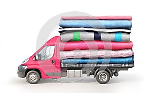 Concept of clothing delivery. A van with a stack of clothes on a platform isolated