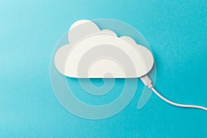 The concept of cloud technologies, cloud storage. A white cable is connected to a cloud on a blue background