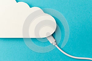 The concept of cloud technologies, cloud storage. A white cable is connected to a cloud on a blue background