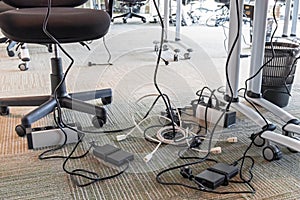 Concept of clutter in office. Unwound and tangled electrical wires under the table. 5S system of lean manufacturing.