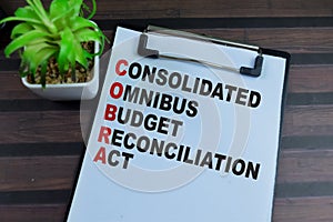 Concept of COBRA - Consolidated Omnibus Budget Reconciliation Act write on paperwork isolated on wooden background