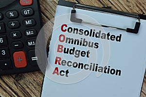 Concept of COBRA - Consolidated Omnibus Budget Reconciliation Act write on paperwork isolated on Wooden Table photo