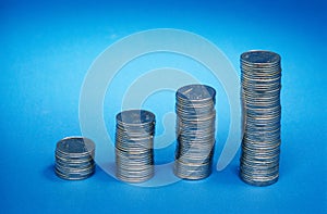 coins showing growth graph on blue background