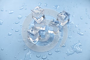 Concept of cold and refreshing. Ice cubes with water drops on a blue background