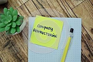 Concept of Company Restructuring write on sticky notes isolated on Wooden Table