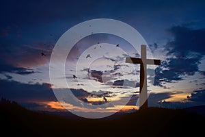 Concept conceptual black cross religion symbol silhouette in grass over sunset