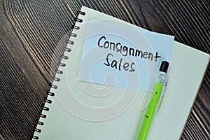 Concept of Consignment Sales write on sticky notes isolated on Wooden Table photo