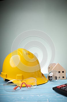 Concept construction home, and safety on work. Personal protective equipment. Yellow hard hat with many mini wood houses, safety