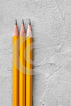 Concept of construction, sharpened pencils on a background of gray plaster texture, space for text