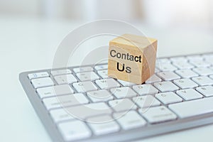 Concept of contact us. wooden cube blocks with contact us on computer keyboard. symbol of connection, email telephone. Technology