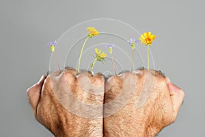 Concept and contrast of hairy man hand and flower