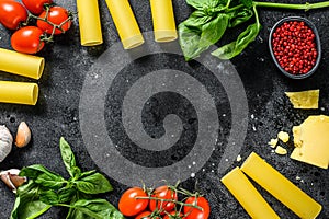 The concept of cooking cannelloni pasta. ingredients Basil, cherry tomatoes, Parmesan, garlic. Black background. top view. Copy