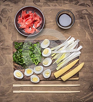 Concept cooking Chinese food, boiled quail eggs with seaweed Chuka, and corn on wooden rustic background top view