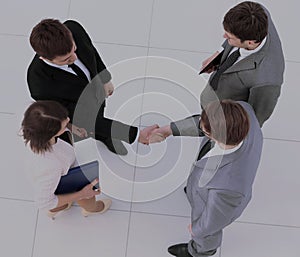 Concept of cooperation: business partners shaking hands after si