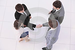 Concept of cooperation: business partners shaking hands after si