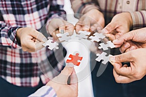 The concept of cooperation. A group of business people assembling jigsaw puzzle. teamwork, help and support in business