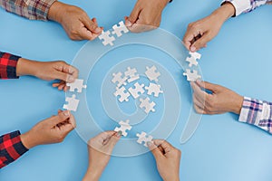 The concept of cooperation. A group of business people assembling jigsaw puzzle. teamwork, help and support in business