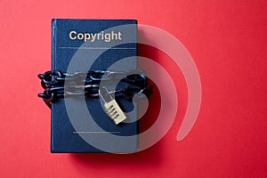 Concept for copyright, patent or intellectual property and idea protection. Book wrapped in a chain with a lock.