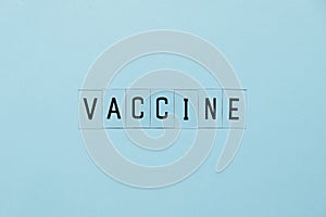 Concept Coronavirus vaccine. Prevent or stop the spread of the COVID-19 worldwide. Letters vaccine on blue background.