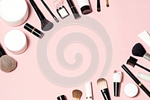 Concept of a cosmetic tubes and cream containers top view on pink background