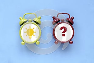 Concept of creative thinking idea and problem solving. Light bulb icon and question mark over alarm clock