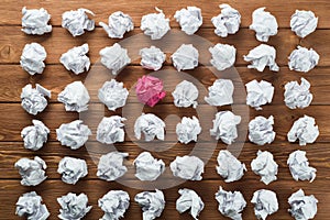 Concept of creativity and inspiration presented by many white paperballs and one color