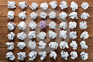 Concept of creativity and inspiration presented by many white paperballs and one color