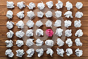 Concept of creativity and inspiration presented by many white paperballs and one color