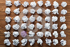 Concept of creativity and inspiration presented by many white paperballs and one color