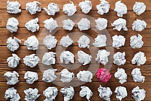 Concept of creativity and inspiration presented by many white paperballs and one color