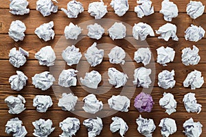 Concept of creativity and inspiration presented by many white paperballs and one color