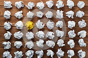 Concept of creativity and inspiration presented by many white paperballs and one color