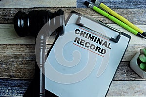 Concept of Criminal Record write on paperwork with gavel isolated on wooden background