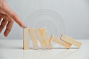 Concept of crisis manager from business liquidation. Hand holds wooden blocks on a white background