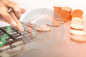 Concept of currency trading. Stack of coins and a hand holding is examining a technical chart of financial instrument