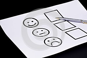 The concept of a customer satisfaction survey and a questionnaire. Provide feedback via a multi-choice form. paper and emoticon