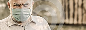 Concept danger of coronavirus for the elderly. Portrait old man in a surgical bandage, coronavirus, medical mask. Old