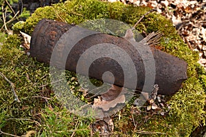Concept of danger: old whizbang, artillery rusty whizzbang high explosive of the Second World War in thicket forest of