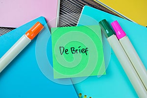 Concept of Debrief write on sticky notes isolated on Wooden Table photo