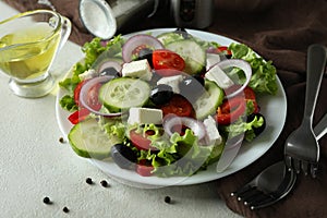 Concept of delicious food with Greek salad on white textured background