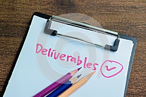 Concept of Deliverables write on paperwork isolated on wooden background photo