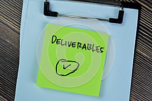 Concept of Deliverables write on sticky notes isolated on Wooden Table photo