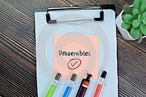 Concept of Deliverables write on sticky notes isolated on Wooden Table