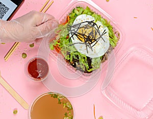 The concept of delivering the popular Korean dish Pibimpab in a lunch box. Purchases by QR code. flatlay on a pink