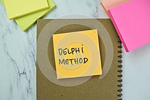 Concept of Delphi Method write on sticky notes isolated on Wooden Table