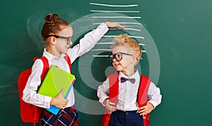 Concept of   development in education. children boy and girl students measure growth about school blackboard