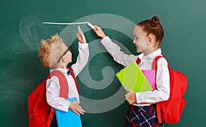 Concept of   development in education. children boy and girl students measure growth about school blackboard