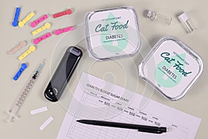 Concept for Diabetes disease with cats with veterinary cat food, glucometer and syringe and blood sugar diary