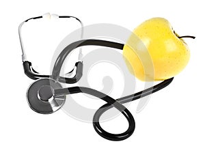 Concept for diet and healthcare - yellow apple and stethoscope on a white background
