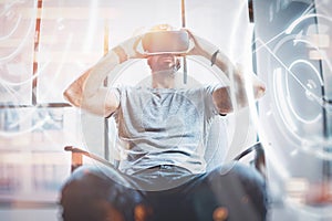 Concept of digital screen,connection and interfaces.Young beraded hipster enjoyingvirtual reality glasses in modern